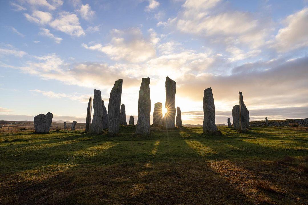 Photo by @acacia.johnson | The sun rises between the Calanais Standing Stones on the Isle of Lewis in Scotland’s Outer Hebrides. At over 5,000 years old, these mysterious stones predate Stonehenge. They are believed to have been used for ritual activity during the Bronze Age, and possibly as an early astronomical observatory.

In the days and nights I shared with these ancient stones, watching the sun, moon, and stars wheel around them in the vast silence of the ether, it was easy to understand why they’ve captivated people’s imaginations for eons. They even inspired Disney’s animated Scottish tale Brave, whose protagonist Merida was guided to her destiny by her own arcane ring of stones. Photographing these megaliths at sunrise, the long shadows they cast over the earth elevated their mythical allure. Click the link in bio to see more of my photos from Scotland. | Be star-struck by Scotland’s film locations! #ScotlandIsCalling @visitscotland