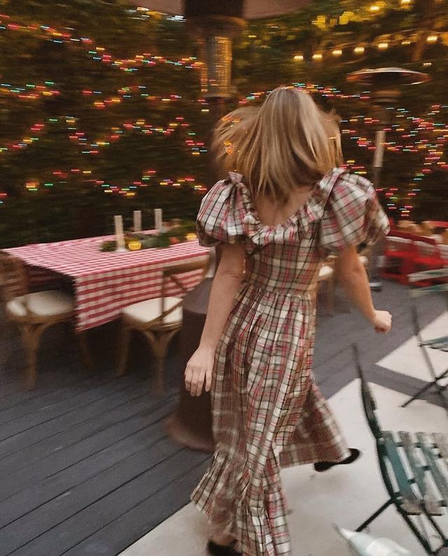 Pre-Holiday party @annielcampbell hostess with the mostest running around in the Modena Dress! 🎁🥂 Most festive, present-like dress in plaid silk taffeta ✨🕊 Available online now for all your holiday festivities. 🥳 Order today by noon PST with 2-day shipping to ensure delivery by 12/24! 🎄

~

Image Description // Annie is captured in mid-stride across a festively decorated outdoor dining space wearing a full-length, plaid dress with puffed sleeves and a ruffled neckline, and black, velvet Mary Jane slippers.